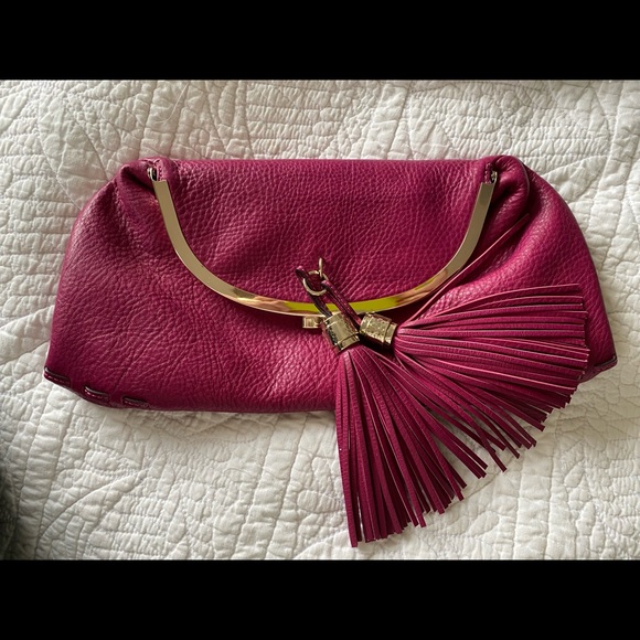 Tumi Handbags - Tumi pink leather clutch w/purple lining and tassels